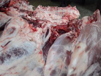 Huge carcasses of cattle lie on a cart. Panorama of carcasses of cows with ribs in the market. Meat carcasses with bones. Pieces of meat are on the counter. Trolley with whole carcasses. Meat rows on the market. Vladimir market, Kyiv. Ukraine. March 29, 2015